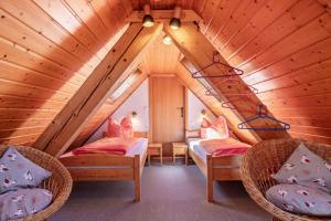 ein Zimmer mit zwei Betten und Stühlen auf dem Dachboden in der Unterkunft Brosihof in Erlenbach