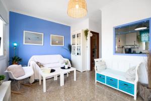 a living room with blue walls and white furniture at Apartamento La Barca - Chipiona in Chipiona
