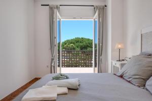 a bedroom with a bed and a large window at Michalete Fernando - Sólo Familias in Conil de la Frontera