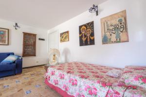 a bedroom with a bed and a blue couch at Casa della Poiana in Lipari