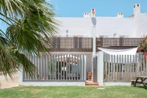 a white fence with a table and a bench at Michalete Fernando - Sólo Familias in Conil de la Frontera