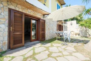 a table with an umbrella next to a house at Casa della Poiana in Lipari