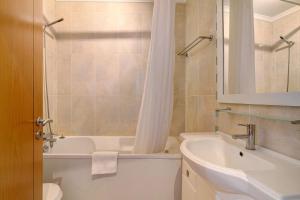 a bathroom with a sink and a tub and a toilet at Quarteira Beach I in Quarteira +16 photos
