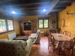 a living room with a couch and a table and chairs at Los Avellanos Casa 3 in Celis