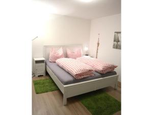 a bedroom with a bed with pink and white pillows at Ferienwohnung im Haus Schwedes in Titisee-Neustadt +24 photos