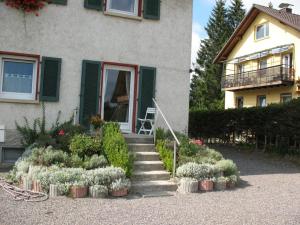 a house with stairs and flowers in front of it at Ferienwohnung im Haus Schwedes in Titisee-Neustadt