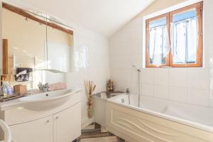 a white bathroom with a tub and a sink at Gites les Renardiers in Peyraube +48 photos