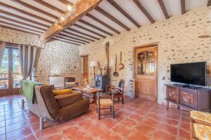 a living room with a couch and a tv at Gites les Renardiers in Peyraube