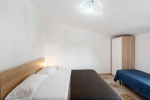 a bedroom with a large white bed and a blue couch at Ce Tour - Casa Cetara Centro 1 in Cetara