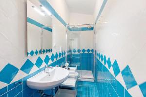 a bathroom with blue and white tiled walls and a sink at Ce Tour - Casa Cetara Centro 1 in Cetara +12 photos