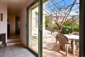 a glass door leading to a patio with a table and chairs at Les Cigales in Cassis +13 photos