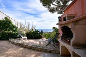 a patio with two chairs and a fireplace at Les Cigales in Cassis
