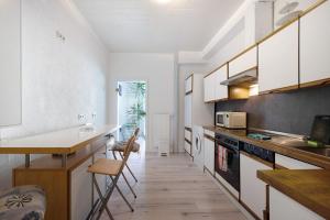 a kitchen with white cabinets and a wooden floor at an der Mosel in Kaisersesch