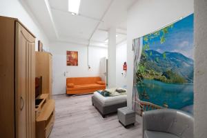a living room with a couch and an orange chair at an der Mosel in Kaisersesch