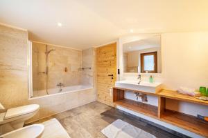 a bathroom with a tub and a sink and a toilet at Ferienhaus Mutlechnerhof in Caines +35 photos