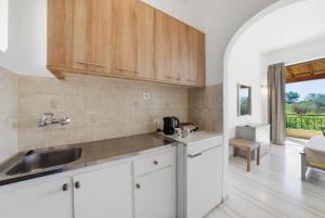 a kitchen with white cabinets and a sink at Alexandra Studio 10 in Lefkimmi +10 photos
