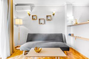a bedroom with a black bed and a table at Unique Apartahotel 3-2 in Torrevieja