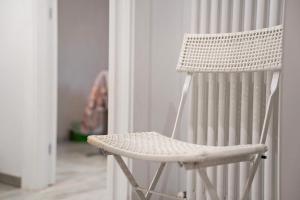 a white rocking chair sitting in a room at La Casa Di Angio - Val D'Intelvi in Lanzo dʼIntelvi