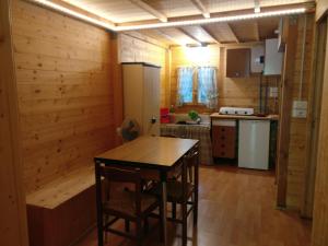 a kitchen with wooden walls and a table and chairs at Le sorgenti - Chalet 42 in Palazzuolo sul Senio