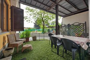 a patio with a table and chairs and a fence at La Casa Di Angio - Val D'Intelvi in Lanzo dʼIntelvi
