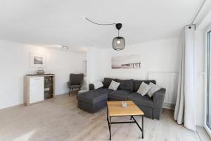 a living room with a couch and a table at Küstenliebe-Fehmarn in Fehmarn