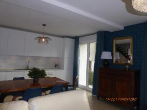a living room with a table and a kitchen at La faustinière in Andonville