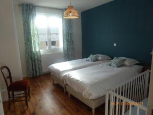 a bedroom with a bed with a blue wall and a window at La faustinière in Andonville