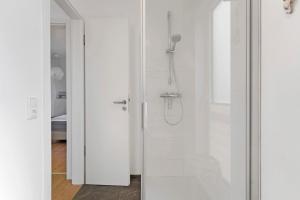 a bathroom with a shower with a glass door at Hausboot Sutje in Großenbrode +17 photos