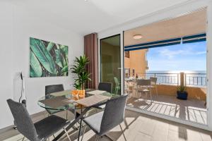 a dining room with a glass table and chairs at 100 Beach Seaview in Torrevieja