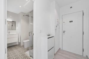 a white bathroom with a shower and a sink at 100 Beach Seaview in Torrevieja +17 photos