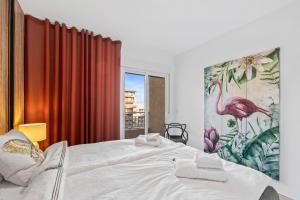 a bedroom with a large bed with a painting of a flamingo at 100 Beach Seaview in Torrevieja