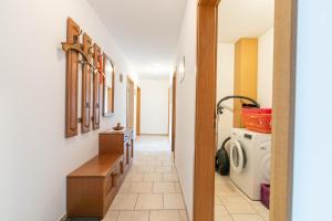 a hallway leading to a laundry room with a washer and dryer at Ferienhof Martens in Schülperweide +40 photos