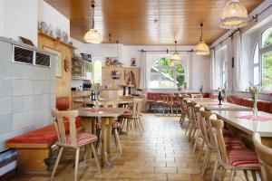 a restaurant with tables and chairs in a room at Kraichgauer Haus in Oberreute