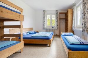 a room with two bunk beds and two windows at Kraichgauer Haus in Oberreute