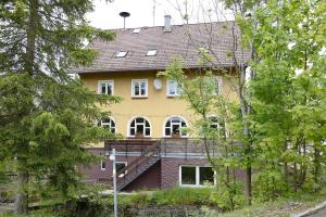 a large yellow house with a porch and a balcony at Kraichgauer Haus in Oberreute