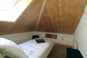 a bed in a room with a wooden ceiling at Charmant petit chalet individuel in Briançon