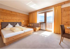ein Schlafzimmer mit einem Bett und einem großen Fenster in der Unterkunft Passerblick in Dorf Tirol + 124 Fotos