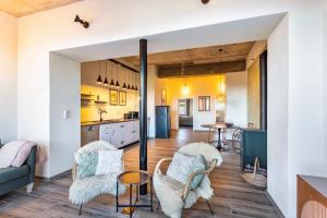 a kitchen and living room with a couch and chairs at Suiten im Alten Berghotel Antonia in Eslohe