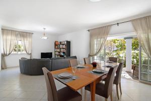 a dining room and living room with a table and chairs at Villa Galé in Guia