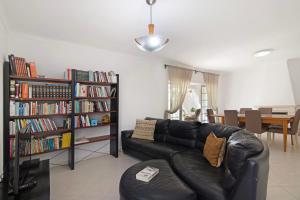 a living room with a black leather couch and book shelves at Villa Galé in Guia