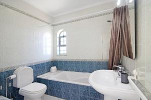 a bathroom with a tub and a toilet and a sink at Villa Galé in Guia +21 photos