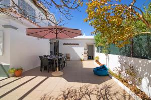 a patio with a table and an umbrella at Villa Galé in Guia