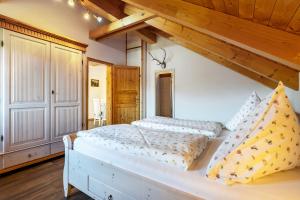 a bedroom with a white bed with a wooden ceiling at Blockhaus - Ferienwohnung Sunrise in Erdmannsdorf
