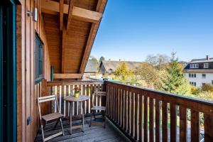 a porch with two chairs and a table on it at Blockhaus - Ferienwohnung Sunrise in Erdmannsdorf