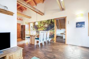 a living room with a television and a table and chairs at Blockhaus - Ferienwohnung Sunrise in Erdmannsdorf