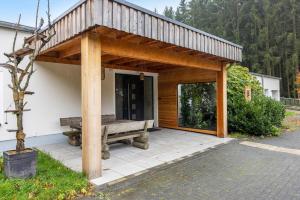 a wooden pavilion with a bench on a patio at Suiten im Alten Berghotel Antonia in Eslohe