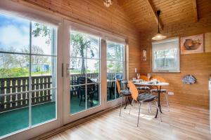 a dining room with windows and a table and chairs at Lillis Ferienhaus Nr 27 in Göhren