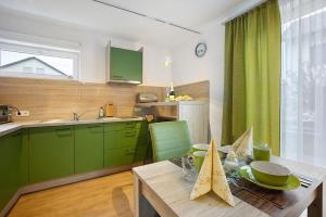 a kitchen with green cabinets and a wooden table at Ferienwohnung am Wiesenweg in Mauerstetten