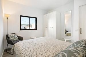 a white bedroom with a bed and a window at Eras Views in Las Eras