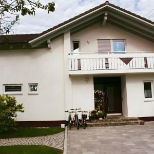 a white house with two bikes parked in front of it at Ferienwohnung am Wiesenweg in Mauerstetten